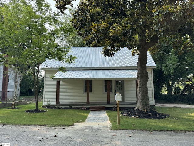 800 W Hampton St, Laurens, SC 29360 - view of front of home with covered porch, a front lawn, and metal roof