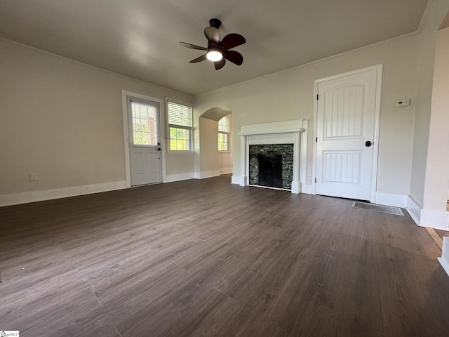 800 W Hampton St, Laurens, SC 29360 - unfurnished living room with a ceiling fan, arched walkways, dark wood-type flooring, a fireplace, and baseboards