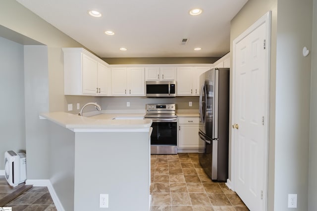 48 Border Ave, Simpsonville, SC 29680 - kitchen featuring appliances with stainless steel finishes, a peninsula, white cabinets, light countertops, and recessed lighting