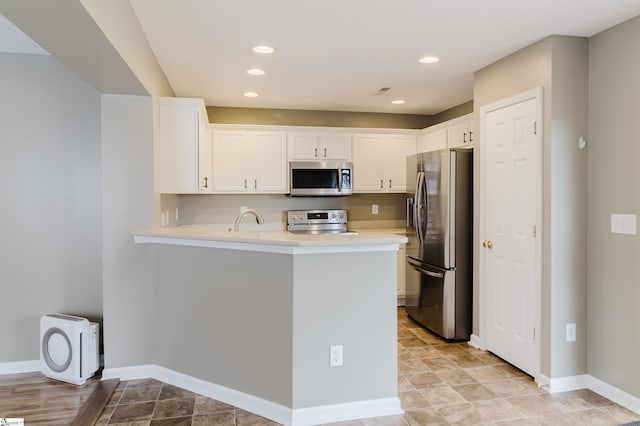 48 Border Ave, Simpsonville, SC 29680 - kitchen featuring stainless steel appliances, white cabinetry, a peninsula, light countertops, and baseboards