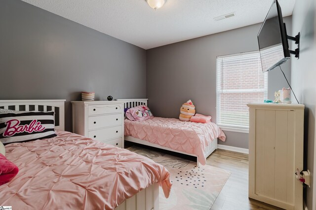 48 Border Ave, Simpsonville, SC 29680 - bedroom featuring wood finished floors, a textured ceiling, and baseboards