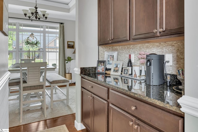 204 Medoc Ln, Moore, SC 26369 - kitchen featuring crown molding, a chandelier, decorative backsplash, dark wood-style floors, and dark stone countertops