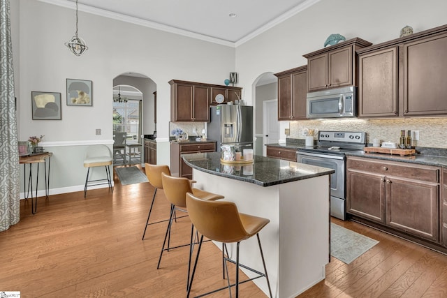 204 Medoc Ln, Moore, SC 26369 - kitchen featuring stainless steel appliances, arched walkways, a center island, light wood finished floors, and crown molding