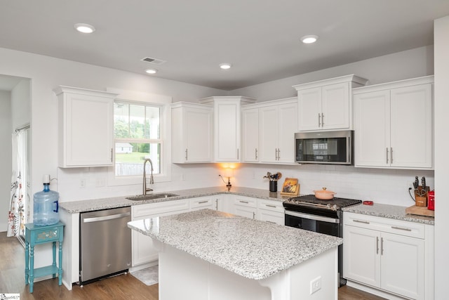 800 Redmill Ln, Duncan, SC 29334 - kitchen featuring appliances with stainless steel finishes, a sink, white cabinets, decorative backsplash, and a center island