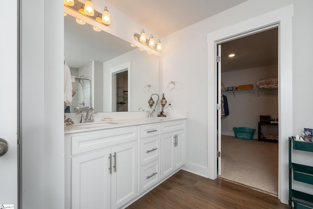 800 Redmill Ln, Duncan, SC 29334 - full bathroom featuring double vanity, a tile shower, a walk in closet, wood finished floors, and baseboards