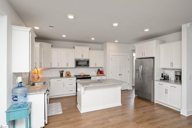 800 Redmill Ln, Duncan, SC 29334 - kitchen featuring appliances with stainless steel finishes, a sink, a center island, white cabinetry, and tasteful backsplash