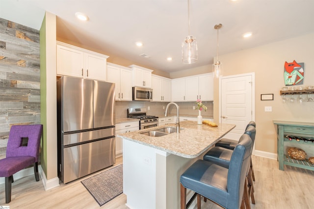 345 Cypress Hollow Trl, Piedmont, SC 29673 - kitchen featuring stainless steel appliances, light wood finished floors, a sink, white cabinets, and light stone countertops