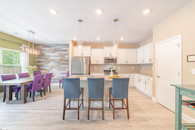 345 Cypress Hollow Trl, Piedmont, SC 29673 - kitchen featuring stainless steel appliances, white cabinets, light wood-style floors, a kitchen island with sink, and recessed lighting