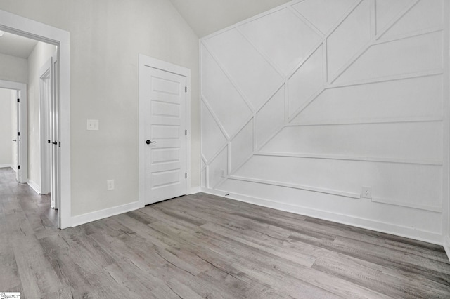 1708 Old Georgia Hwy, Gaffney, SC 29341 - unfurnished room with wood finished floors, a decorative wall, baseboards, and lofted ceiling