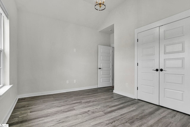 1708 Old Georgia Hwy, Gaffney, SC 29341 - unfurnished bedroom with wood finished floors, a chandelier, a closet, baseboards, and high vaulted ceiling