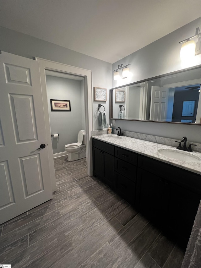 9 Lee St, Liberty, SC 29657 - bathroom featuring double vanity, toilet, wood finished floors, and baseboards
