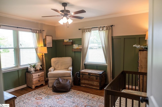 113 Hardy St, Williamston, SC 29697 - bedroom featuring wood finished floors, multiple windows, a crib, ornamental molding, and a decorative wall
