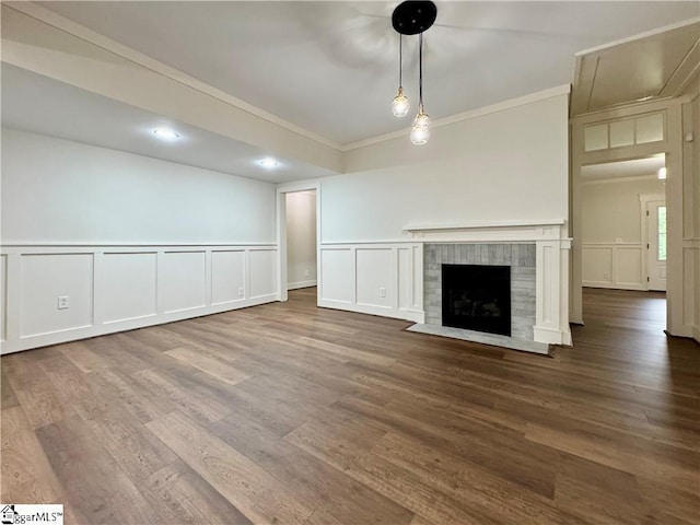 800 Holiday Dam Rd, Honea Path, SC 29654 - unfurnished living room with a decorative wall, ornamental molding, wood finished floors, a tiled fireplace, and a wainscoted wall