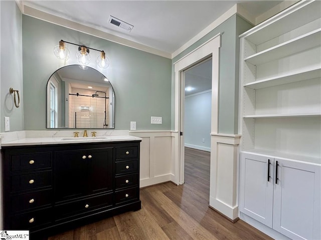 800 Holiday Dam Rd, Honea Path, SC 29654 - bathroom featuring wood finished floors, tiled shower, vanity, a wainscoted wall, and a decorative wall
