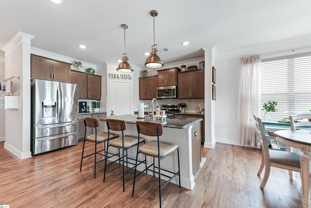 647 Fern Hollow Trl, Anderson, SC 29621 - kitchen with stainless steel appliances, dark brown cabinetry, baseboards, a breakfast bar, and crown molding