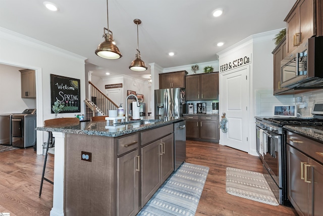 647 Fern Hollow Trl, Anderson, SC 29621 - kitchen featuring appliances with stainless steel finishes, separate washer and dryer, crown molding, a kitchen bar, and dark stone counters