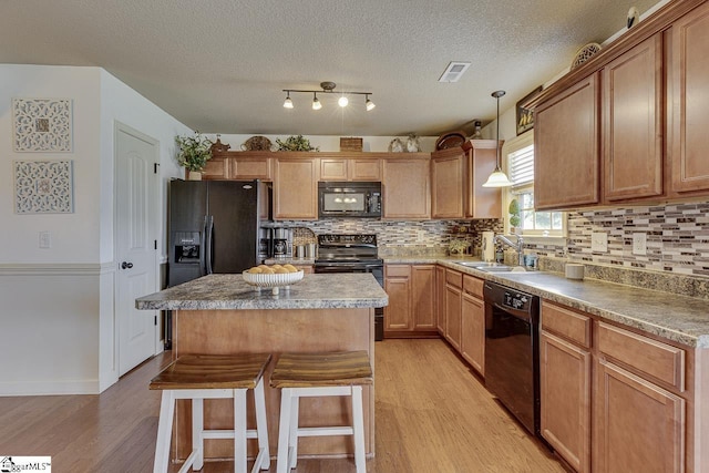 809 Dove Creek Ct, Boiling Springs, SC 29316 - kitchen with black appliances, a sink, light wood-style floors, backsplash, and a kitchen island