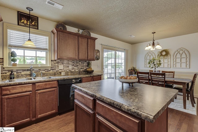 809 Dove Creek Ct, Boiling Springs, SC 29316 - kitchen featuring black dishwasher, a sink, dark countertops, a textured ceiling, and wood finished floors