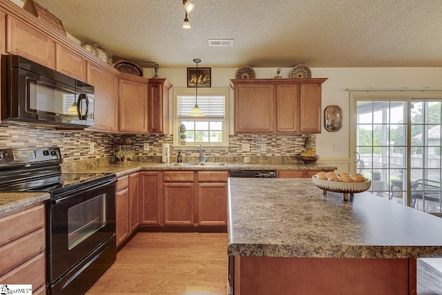 809 Dove Creek Ct, Boiling Springs, SC 29316 - kitchen with black appliances, a textured ceiling, a sink, light wood-style floors, and tasteful backsplash