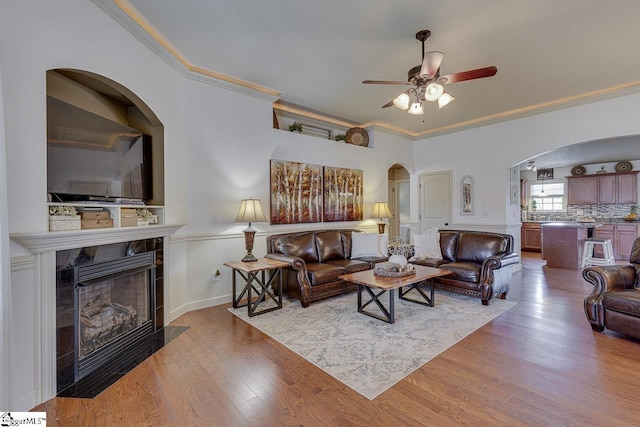 809 Dove Creek Ct, Boiling Springs, SC 29316 - living area featuring arched walkways, a fireplace, crown molding, ceiling fan, and wood finished floors