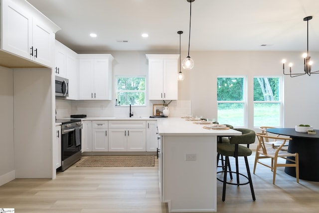 168 Dunbar St, Wellford, SC 29385 - kitchen with appliances with stainless steel finishes, a sink, decorative backsplash, light wood finished floors, and recessed lighting