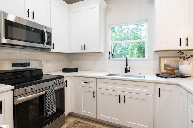 168 Dunbar St, Wellford, SC 29385 - kitchen featuring appliances with stainless steel finishes, a sink, white cabinets, and light countertops