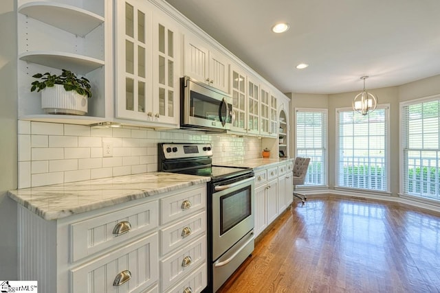 182 Roundstone Dr, Inman, SC 29349 - kitchen featuring stainless steel appliances, open shelves, light wood finished floors, white cabinets, and tasteful backsplash