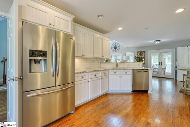 182 Roundstone Dr, Inman, SC 29349 - kitchen with appliances with stainless steel finishes, a peninsula, white cabinets, light wood-type flooring, and recessed lighting