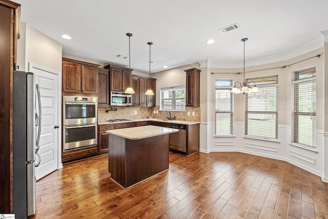 135 Adams Creek Pl, Simpsonville, SC 29681 - kitchen with stainless steel appliances, dark wood-style floors, a sink, a chandelier, and a center island