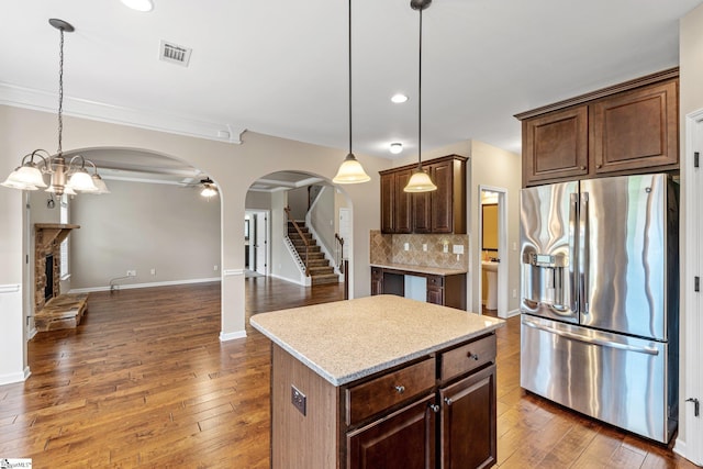 135 Adams Creek Pl, Simpsonville, SC 29681 - kitchen featuring stainless steel fridge with ice dispenser, arched walkways, open floor plan, light countertops, and tasteful backsplash