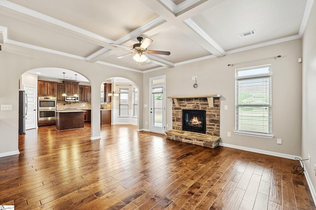 135 Adams Creek Pl, Simpsonville, SC 29681 - unfurnished living room with arched walkways, a ceiling fan, dark wood finished floors, beamed ceiling, and baseboards