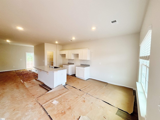 209 Islay Way, Anderson, SC 29621 - kitchen with a sink, white cabinetry, a center island with sink, baseboards, and recessed lighting