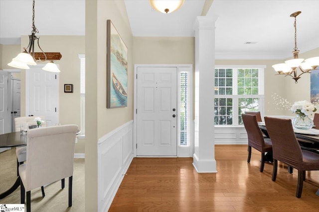 415 Plamondon Dr, Simpsonville, SC 29680 - entrance foyer featuring a chandelier, wood finished floors, a wainscoted wall, decorative columns, and a decorative wall