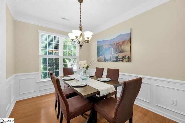 415 Plamondon Dr, Simpsonville, SC 29680 - dining room featuring a chandelier, light wood-type flooring, ornamental molding, wainscoting, and a decorative wall