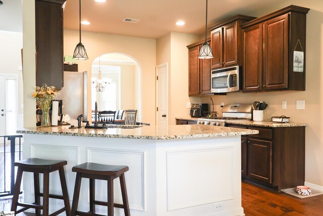354 Harkins Bluff Dr, Greer, SC 29651 - kitchen featuring stainless steel microwave, gas stove, arched walkways, light stone countertops, and dark wood-style floors