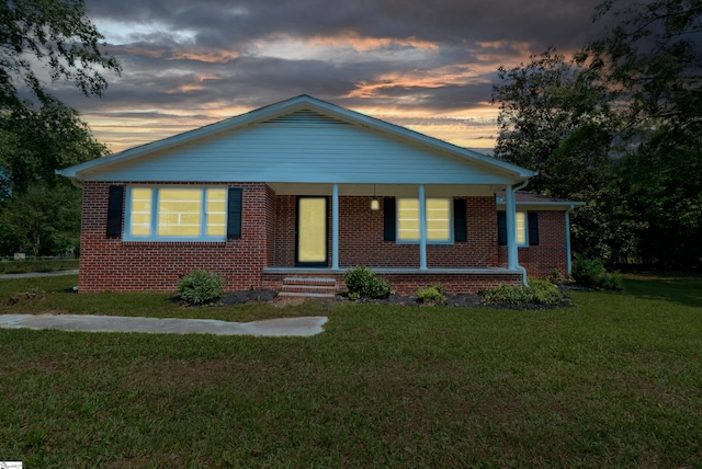 231 E Hampton Ave, Honea Path, SC 29654 - view of front facade featuring a lawn, brick siding, and covered porch