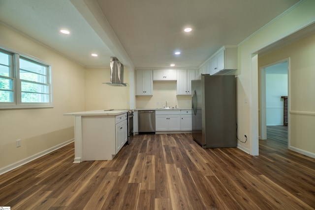 231 E Hampton Ave, Honea Path, SC 29654 - kitchen with stainless steel appliances, wall chimney range hood, a peninsula, crown molding, and dark wood-type flooring