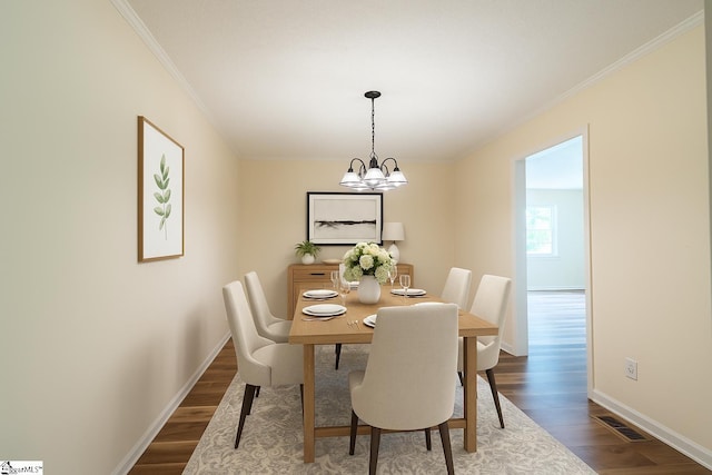 231 E Hampton Ave, Honea Path, SC 29654 - dining area with dark wood finished floors, ornamental molding, baseboards, and a chandelier