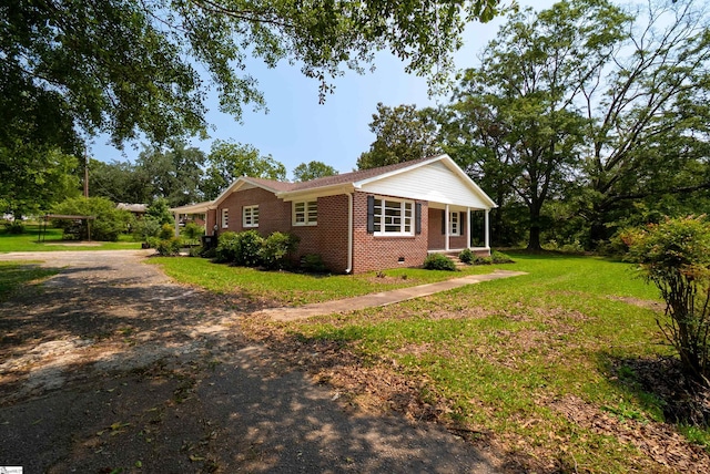 231 E Hampton Ave, Honea Path, SC 29654 - view of front of house with brick siding, a front lawn, dirt driveway, a porch, and crawl space