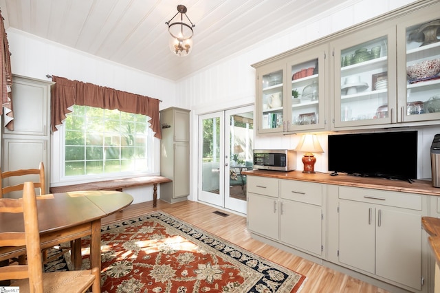 102 Todd Ave, Laurens, SC 29360 - kitchen with stainless steel microwave, crown molding, light wood-style flooring, glass insert cabinets, and wood ceiling