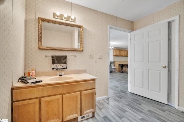 207 Starnes Rd, Laurens, SC 29360 - bathroom with wood finished floors, wallpapered walls, vanity, and baseboards