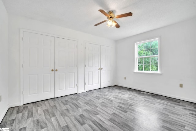 207 Starnes Rd, Laurens, SC 29360 - unfurnished bedroom featuring two closets, wood finished floors, baseboards, and ceiling fan