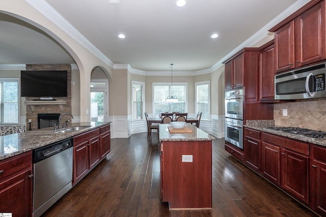 37 Wild Eve Way, Greer, SC 29650 - kitchen featuring stainless steel appliances, a sink, reddish brown cabinets, arched walkways, and stone counters
