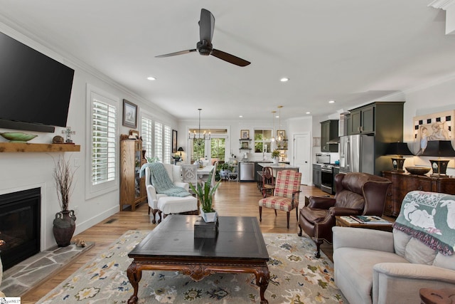 208 Deer Thicket Way, Taylors, SC 29687 - living area featuring ceiling fan, a glass covered fireplace, ornamental molding, light wood-type flooring, and baseboards