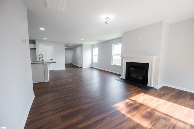 1305 Ledsham Ct, Greer, SC 29651 - unfurnished living room featuring baseboards, a glass covered fireplace, dark wood finished floors, and recessed lighting