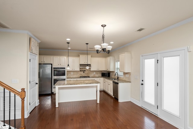 101 Kings Heath Ln, Simpsonville, SC 29680 - kitchen featuring stainless steel appliances, a sink, backsplash, a center island, and ornamental molding