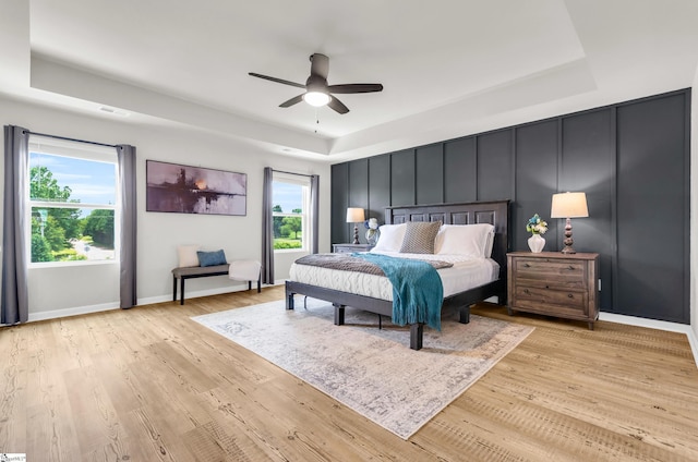 7110 Luna Mae Ct, Boiling Springs, SC 29316 - bedroom featuring a raised ceiling, multiple windows, light wood-style flooring, and baseboards