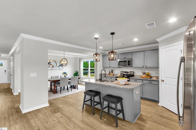 7110 Luna Mae Ct, Boiling Springs, SC 29316 - kitchen featuring stainless steel appliances, gray cabinetry, a sink, ornamental molding, and light stone counters
