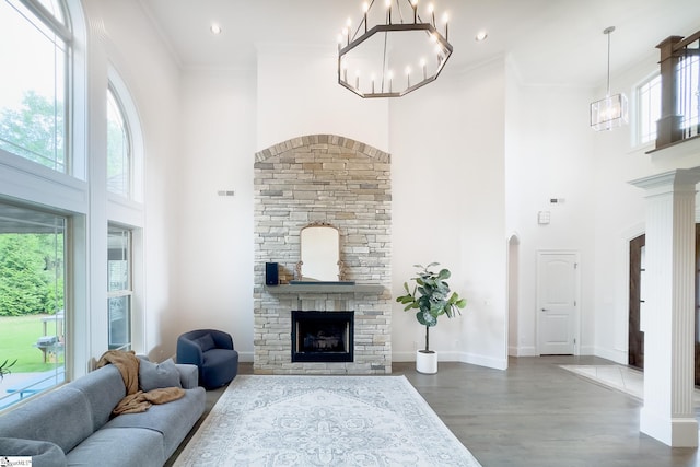 740 N Alamosa Dr, Boiling Springs, SC 29316 - living room featuring arched walkways, a stone fireplace, a towering ceiling, wood finished floors, and a chandelier