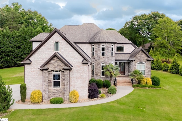 740 N Alamosa Dr, Boiling Springs, SC 29316 - french country style house featuring a front yard, stone siding, roof with shingles, and brick siding